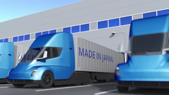 Trailer Trucks with MADE IN JAPAN Text Being Loaded at Warehouse alt