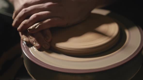 Artisan Hands Forming a Plate From Clay on a Potter's Wheel in Slow Motion alt
