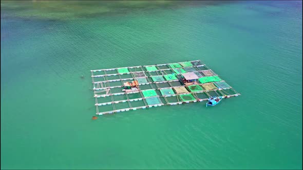 Close Aerial Motion Around Floating Farm with House Boat alt