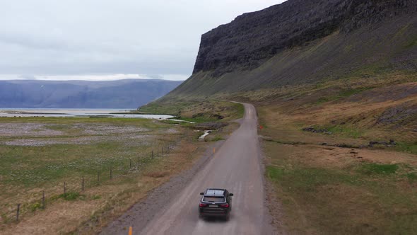 Aerial of Car Driving Along an Empty Rural Road In Iceland alt