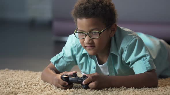 Afro-American Boy Absorbedly Playing on New Video Game Console Activity alt