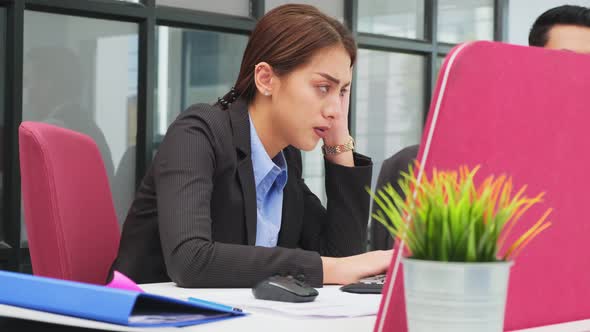 Sickness syndrome in office, Asian young businesswoman working on computer has headache from work. alt