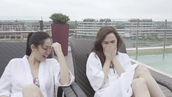 Women laughing while relaxing together at spa