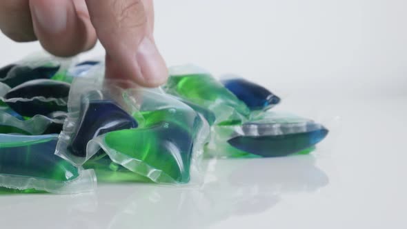 Hand takes one from pile of laundry pods 4K video