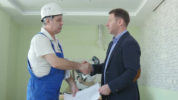 Handsome Construction Businessmans In Protective Helmets Are Shaking Hands At