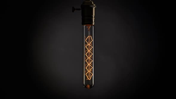 Retro Old Light Bulb Lamp Blinking and Swinging on the Wind in the Night alt