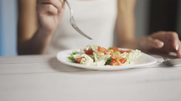 женщина ест полезный салат из овощей