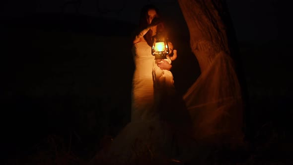 Scary Woman with a Lantern in Night Scene - Spooky Image of a Scary Woman with Dark Eyes  alt