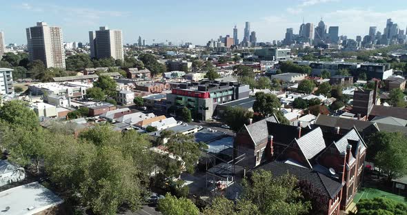 Smooth ascend and reveal of Melbourne CBD skyline and commission towers with old school in foregroun alt