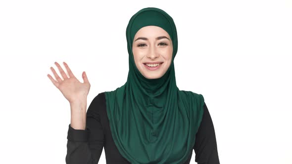 Portrait of Friendly Oriental Woman in Traditional Arabic Scarf Welcoming and Greeting with Waving