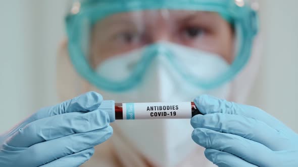 Close Up of Doctor Holding Test Tube with Covid-19 Antibodies on Bright Background. alt