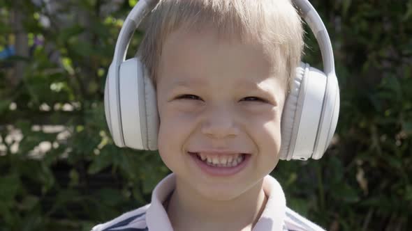 Portrait of Cute Little Boy With Headphones Listening to Music
