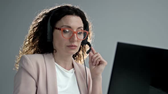 Customer Support Agent or Call Center with Headset Works on Desktop Computer While Supporting the alt