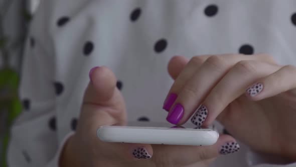 Manicured Female Hands with Stylish Pink Nails Holding Mobile Phone alt