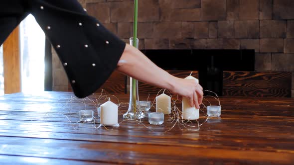 Woman Standing Decoration Candles on Table for Holiday Dinner alt