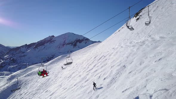 Drone Aerial Ski Couple Sitting on Chair Lift alt
