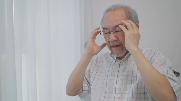 Asian senior man having headache. Stressed and depressed from health problem