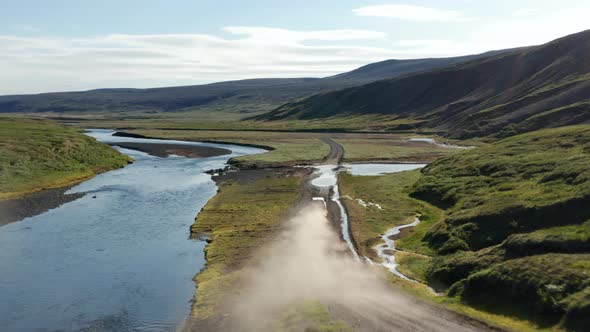 Drone View Vehicle Speeding on Dust Road in Iceland Exploring Amazing Landscape alt