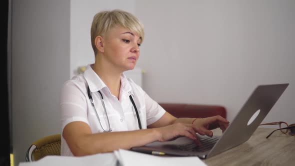 The Blonde Adult Women Doctor is Checking the Data About Patients