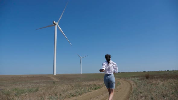 Young Woman in a Shirt and Denim Shorts Walks alt