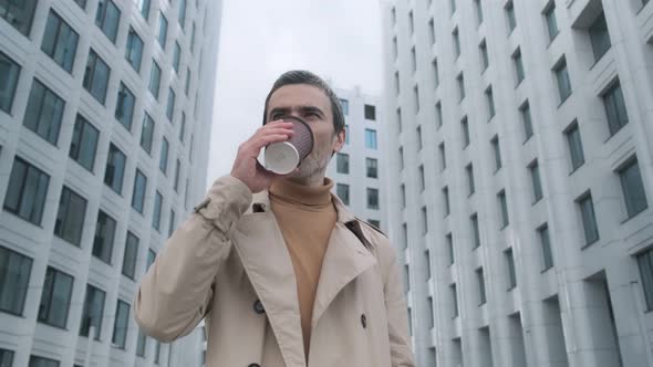 Close-up time-lapse shot of a young bearded man standing on a city street and looking alt