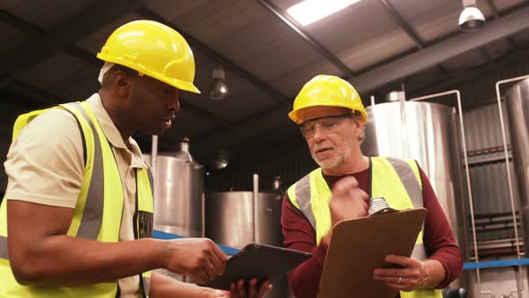 Worker using digital tablet while writing on clipboard alt