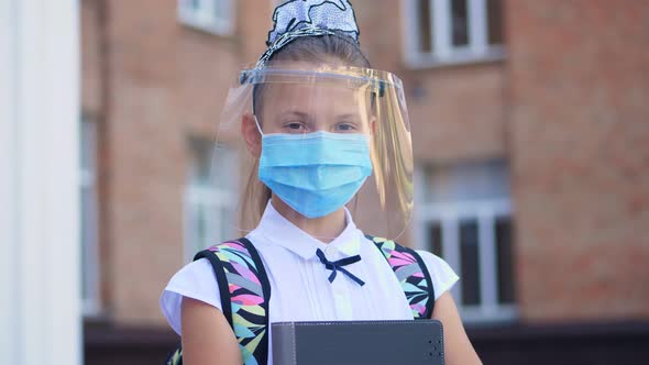 Outdoors Portrait of Schoolgirl, Teenage Girl, in Medical Mask and Protective Face Shield, with alt