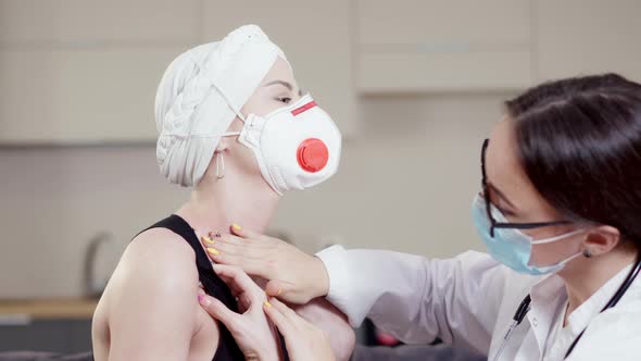 Closeup of Professional Caucasian Female Doctor Examining Patient in Covid19 Respirator Indoors alt