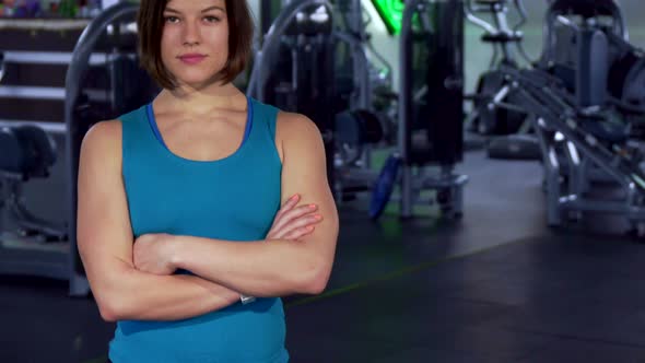 Fitness Woman Keeps Arms Crossed on Her Chest alt