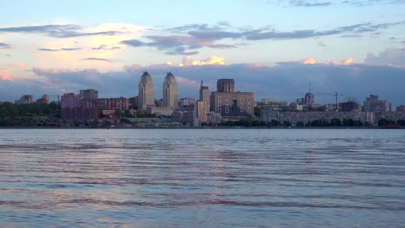 Dnipro city centre and Sicheslavskaya embankment in the rays of the sunset, view from the river.