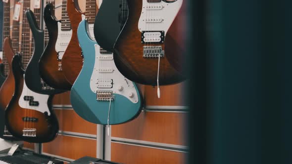 Many New Different Multicolored Electric Guitars are Sold in the Store alt