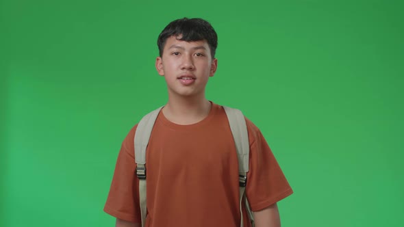 The Front View Of Asian Boy Student Walking To School On Green Screen Chroma Key alt