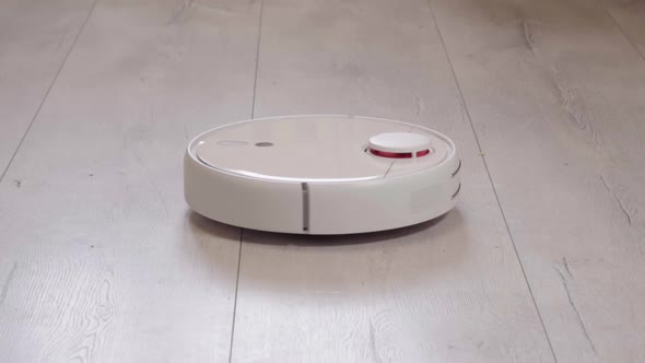 Robot vacuum cleaner vacuuming the floor in the room. Smart home with automated devices alt
