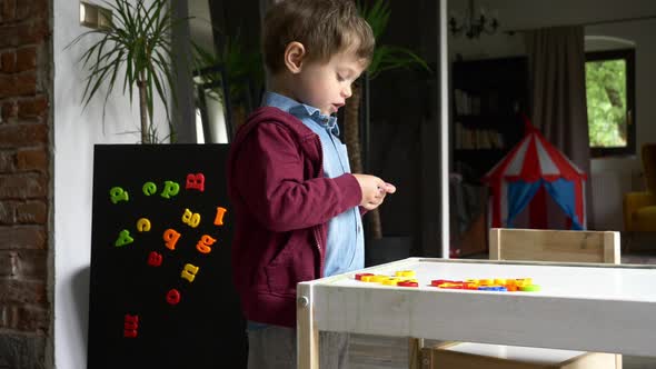 little boy learns and play with letters at home