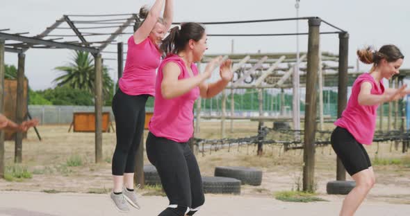 Female friends enjoying exercising at boot camp together alt