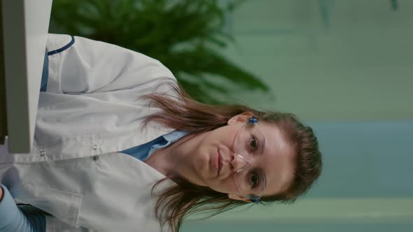 Vertical Video Pov of Botanist Woman in White Coat Listening Chemists Team During Online Videocall alt