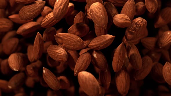Super Slow Motion Shot of Almonds Flies After Being Exploded Against Black Background 1000Fps alt