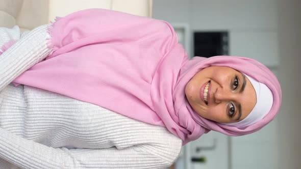 Muslim Woman Wearing Hijab Using Smartphone for Video Call Vertical alt