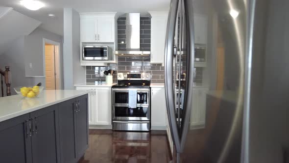 real estate high end kitchen reveal from behind stainless fridge smooth gimbal alt