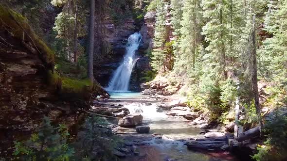Aerial Towards Hidden Gem of Waterfall with Blue Water in Gorge of Colorado alt
