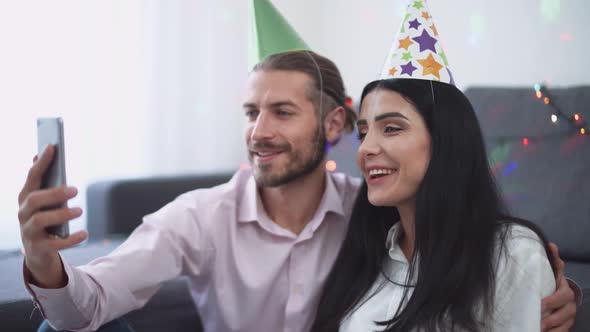 Celebrating Christmas, a Young Couple Sits on the Floor of Their New Apartment and Wishes Their alt