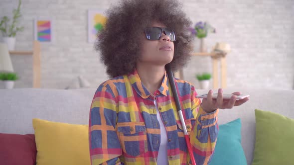 African American Woman with an Afro Hairstyle Visually Impaired Uses Voice Assistant alt