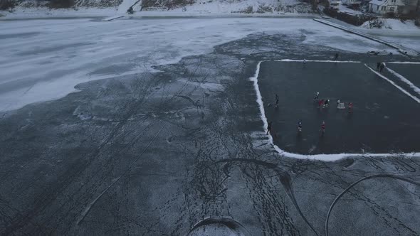 Drone View of a Frozen Lake with Two Ice Hockey Rinks Children Train on a Winter Day