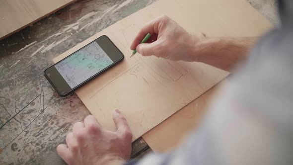 Carpenter Uses Mobile Phone for Drawing Details