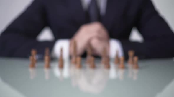 Man Moving Pawn in Chess Game, Involving Voters in Unfair Political Strategy alt