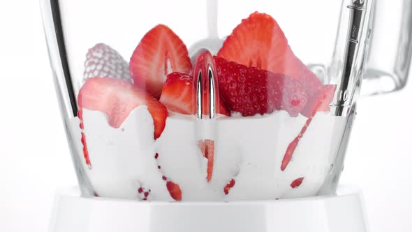 strawberry smoothie. pouring milk in blender for making strawberry smoothie. 4K UHD video alt