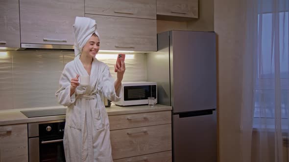 Girl in Bathrobe with Towel on Her Head Uses Phone for Work From Home Slow Motion alt