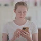 Beautiful Young Woman Using Smartphone for Browsing Internet and Messaging