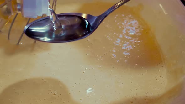 The Process of Making Liquid Dough for Frying Pancakes Dosing with a Tablespoon of Vegetable Oil