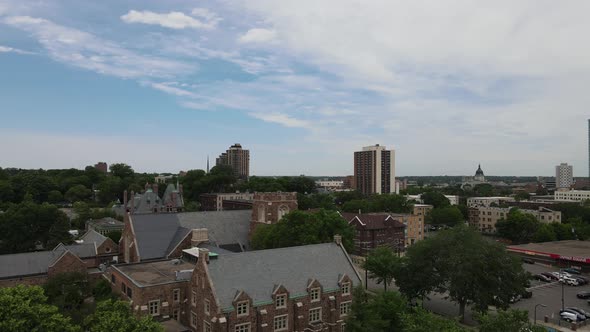 Pan up to overlook cityscape of Minneapolis, Minnesota, with blue sky and white clouds.